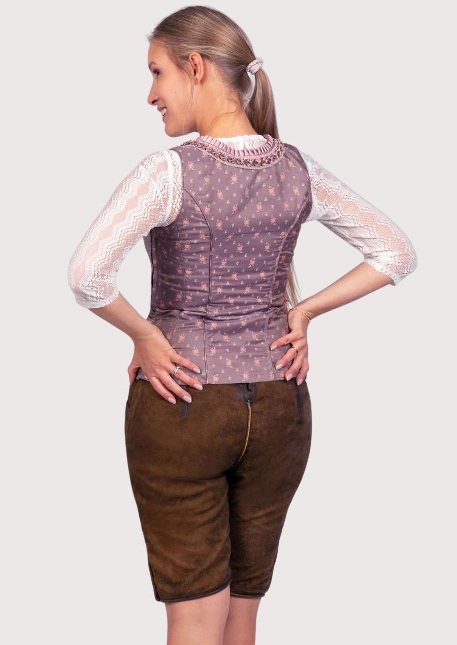 Authentic Alpine women's festival outfit featuring embroidered leather lederhosen, decorative bodice, and traditional styling.