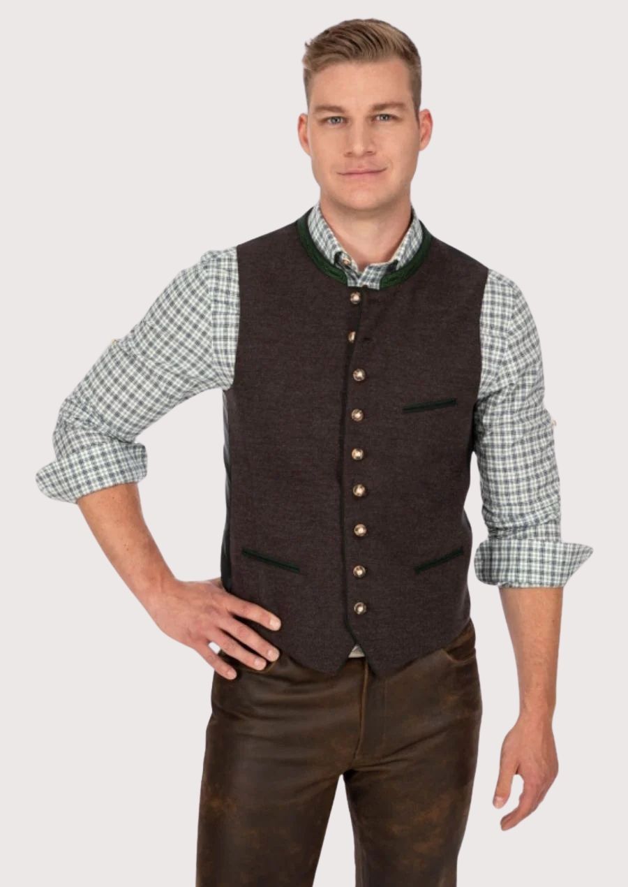Man in classic Bavarian vest with green accents and leather trousers for Oktoberfest

