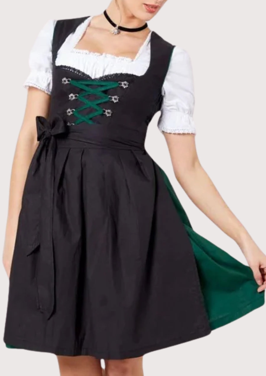 Black traditional dirndl dress featuring green lace-up bodice, white puff-sleeve blouse, and contrasting green skirt panel in classic Alpine women’s fashion.