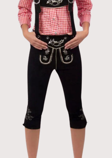 Black women’s traditional Bundhosen trousers with suspenders, ornate alpine embroidery, and classic Bavarian folkwear styling.