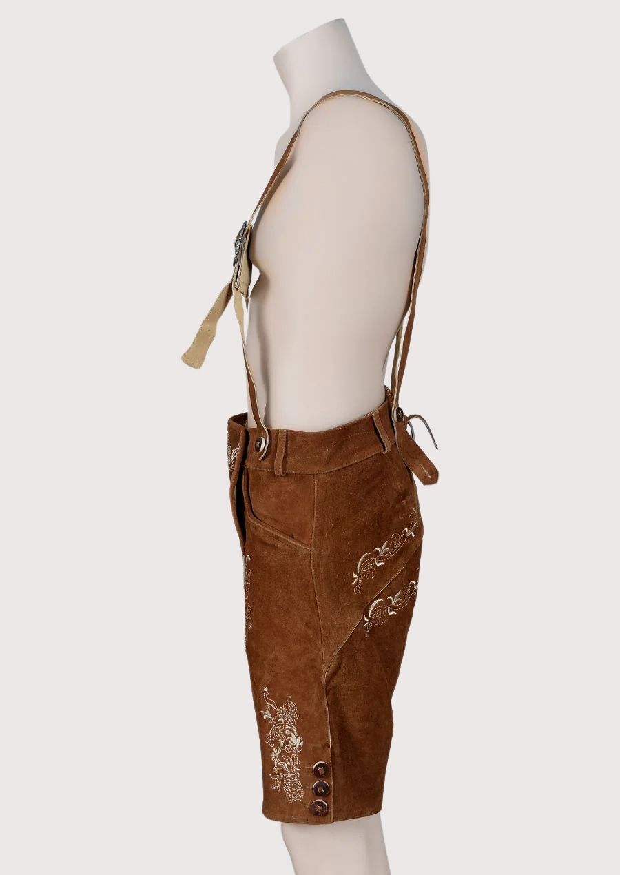 Brown goatskin suede lederhosen with suspenders, ornate cream embroidery, and traditional Bavarian craftsmanship