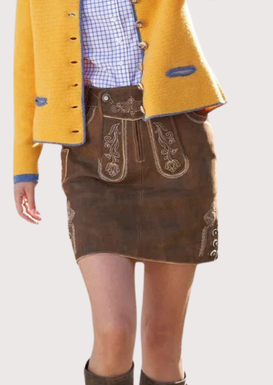 Women wearing brown embroidered lederhosen skirt paired with yellow alpine jacket, showcasing traditional Bavarian trachten fashion style.