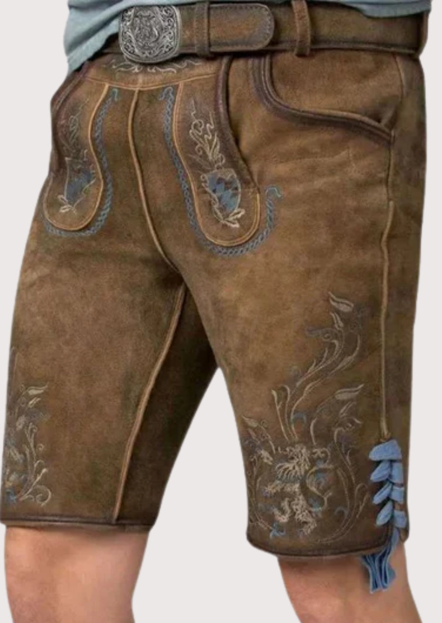 Brown traditional lederhosen featuring intricate blue floral embroidery, decorative stitching, side lacing, and a classic Alpine leather finish.