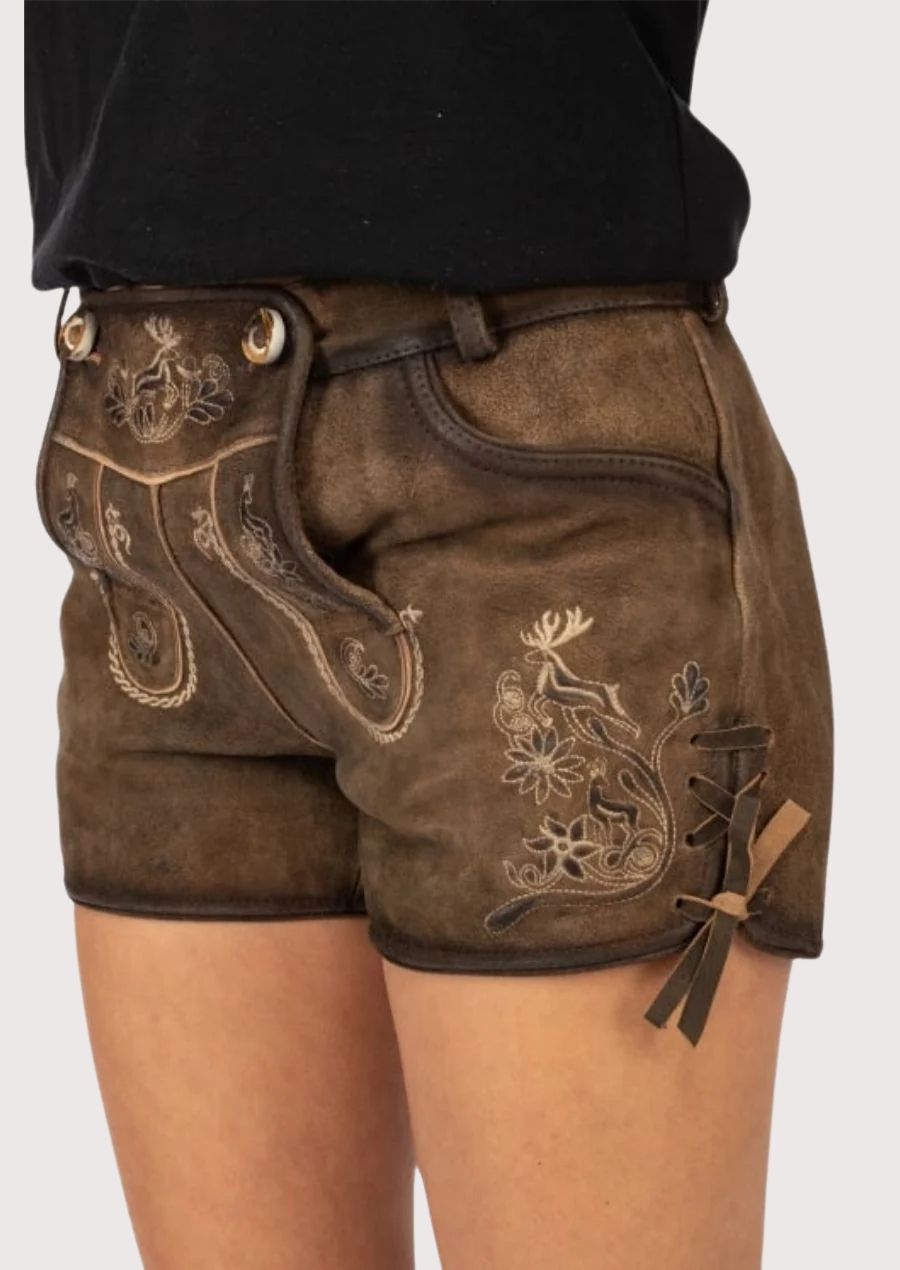 Women's lederhosen featuring Edelweiss-inspired embroidery, vintage suede texture, and traditional German styling.