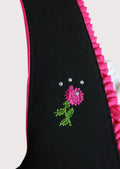 Elegant Bavarian Dirndl featuring a black embroidered bodice, bright pink satin apron, decorative corset lacing, and feminine Alpine design.