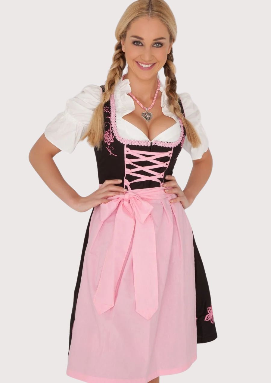 Women's Bavarian Dirndl dress with a black embroidered bodice, pastel pink corset lacing, matching apron, and traditional Alpine festival design.