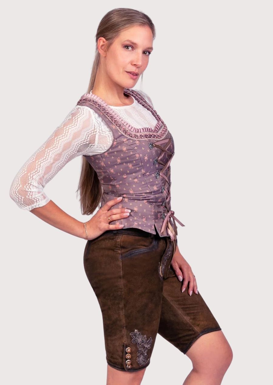Elegant women's Trachten lederhosen set with embroidered knee-length shorts, lace sleeves, and Alpine-inspired detailing.