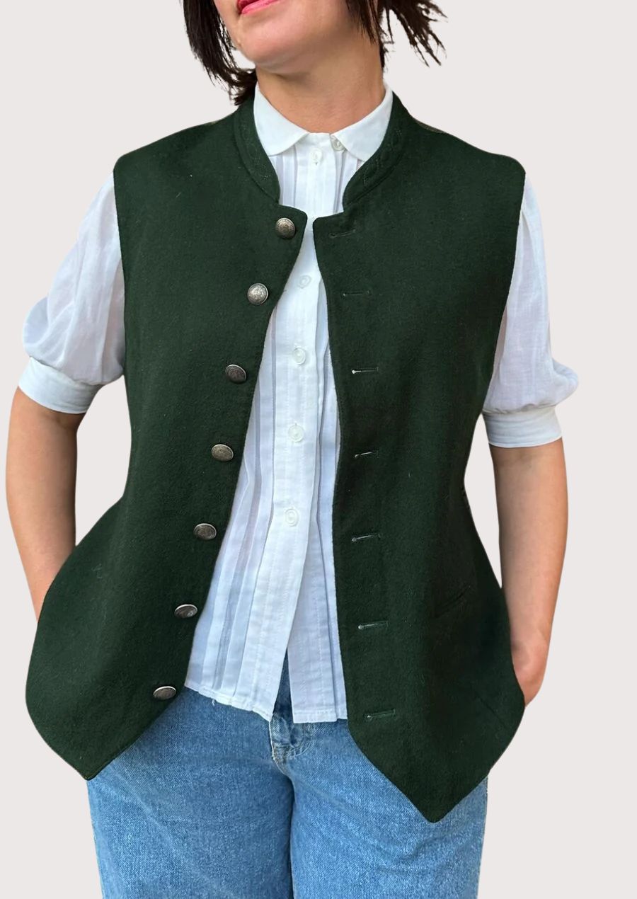Woman wearing dark green traditional buttoned vest.