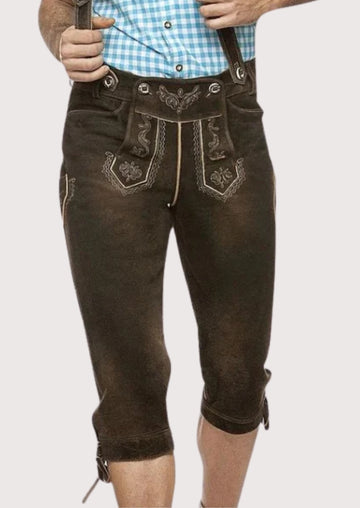 Men wearing traditional brown leather lederhosen with suspenders, fine Alpine embroidery, knee-length cut, and classic Bavarian folk style.