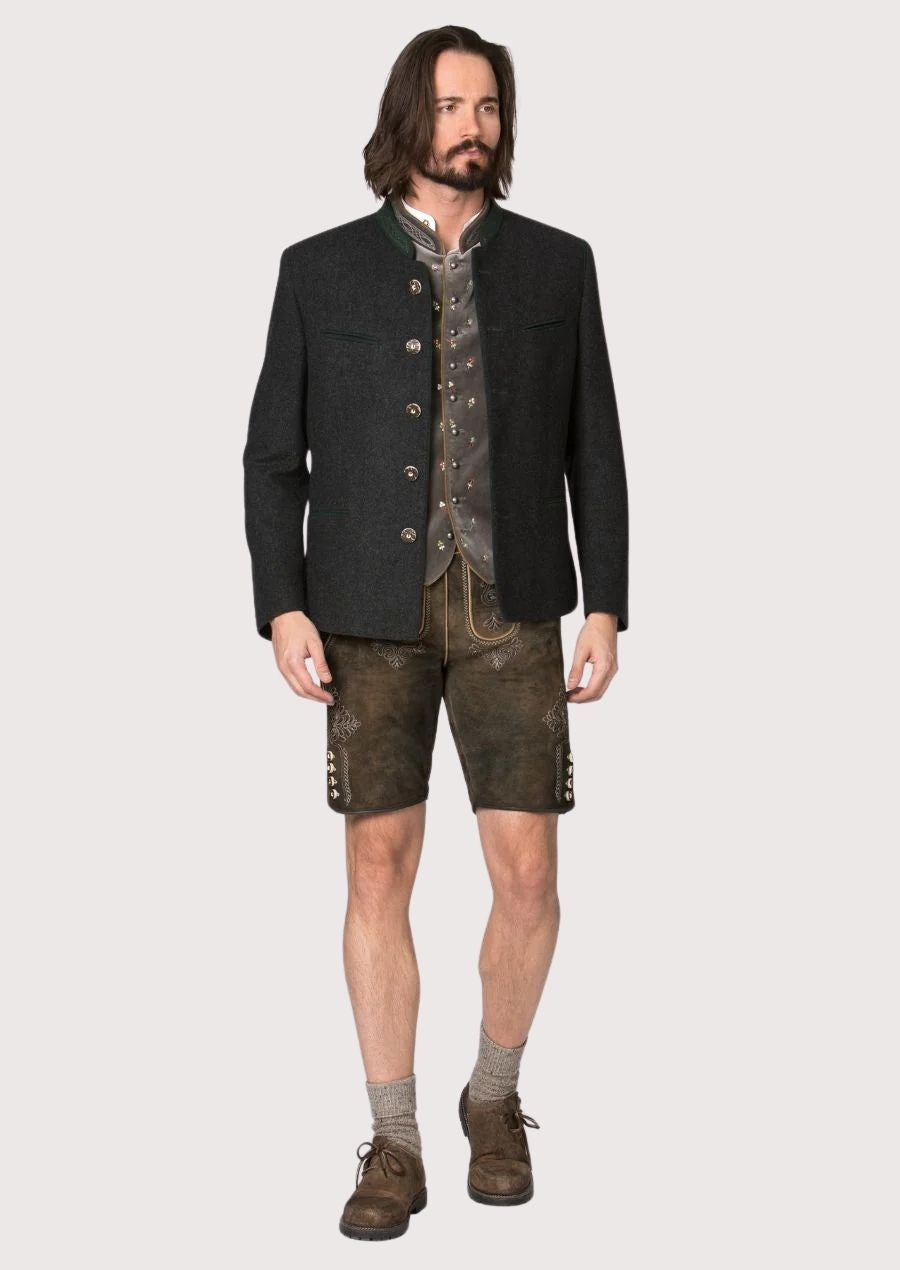 Man wearing traditional Bavarian Trachten jacket in charcoal with green accents and horn style buttons, styled for Oktoberfest with lederhosen.