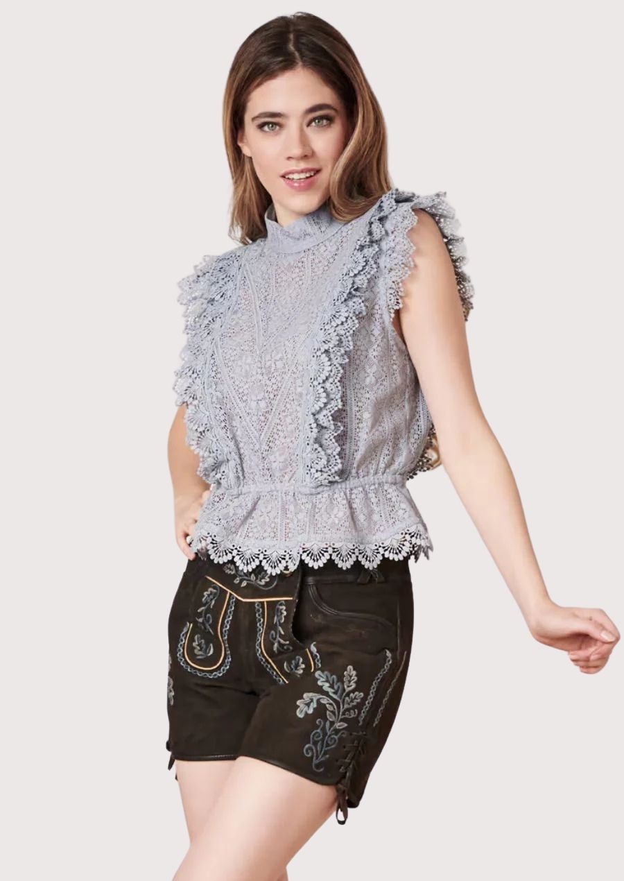 Modern Oktoberfest women’s lederhosen styled with intricate lace blouse and folk details