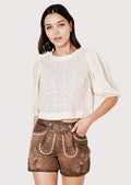 Oktoberfest women’s lederhosen outfit combining classic brown leather shorts and lace blouse