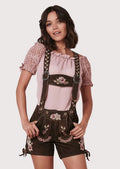 Women's Alpine outfit with embroidered lederhosen, decorative suspenders, and a feminine pink traditional blouse.