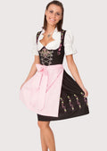 Black embroidered Dirndl dress for women with a pastel pink apron, floral embroidery, lace-up bodice, white puff sleeve blouse, and authentic Oktoberfest styling.