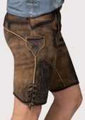 Traditional lederhosen crafted from brown suede with gothic-inspired embroidery and engraved buckle