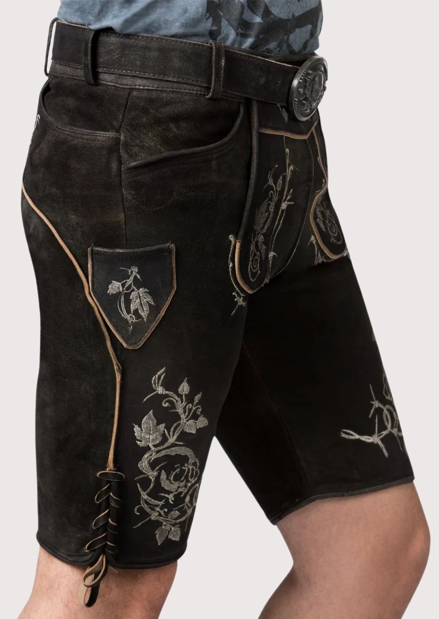 Authentic black lederhosen featuring detailed silver skull artwork and decorative embroidered accents
