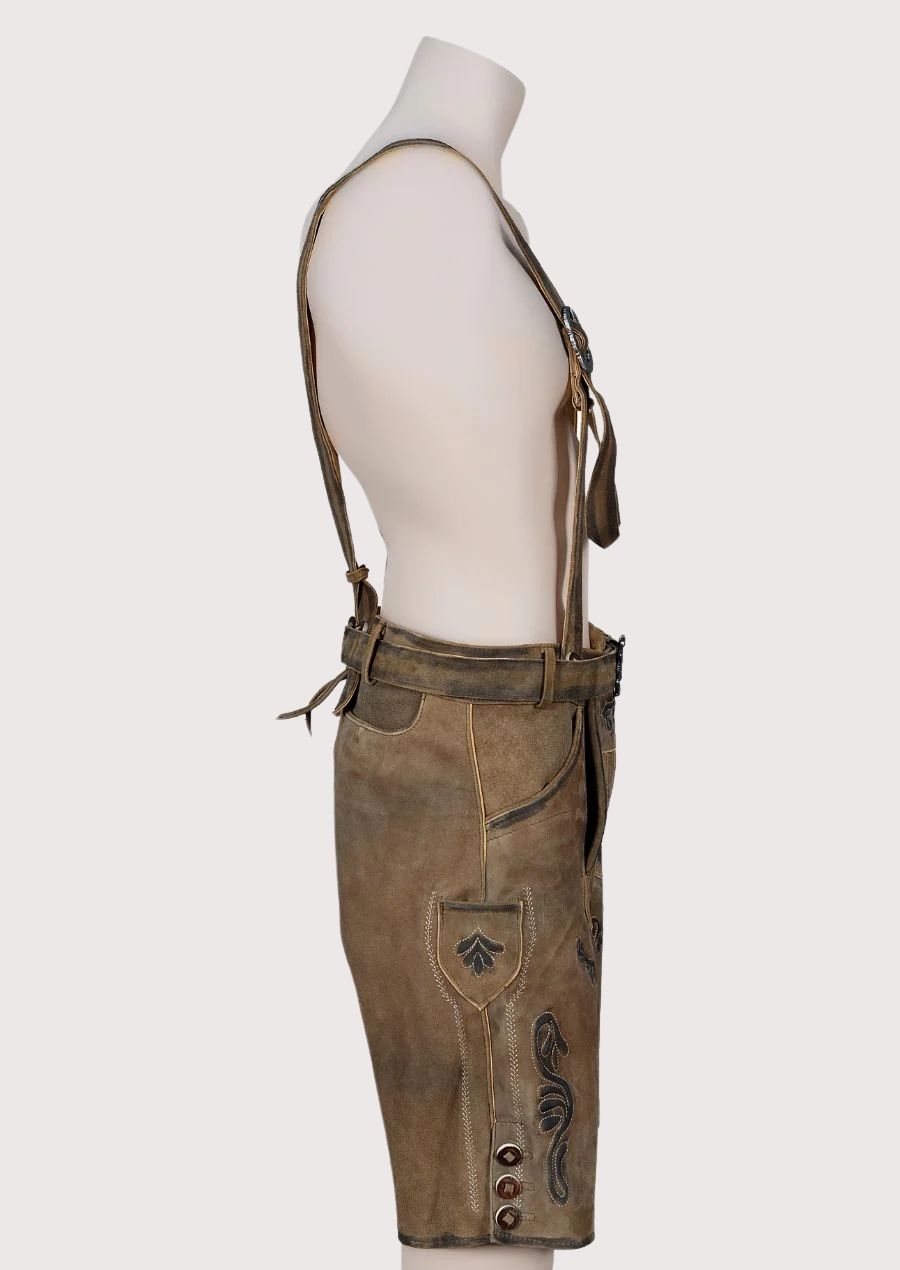 Traditional brown leather lederhosen featuring decorative suspenders, embroidery, and Alpine heritage styling