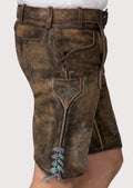 Rustic German lederhosen shorts showcasing heritage-inspired blue embroidery and vintage leather texture