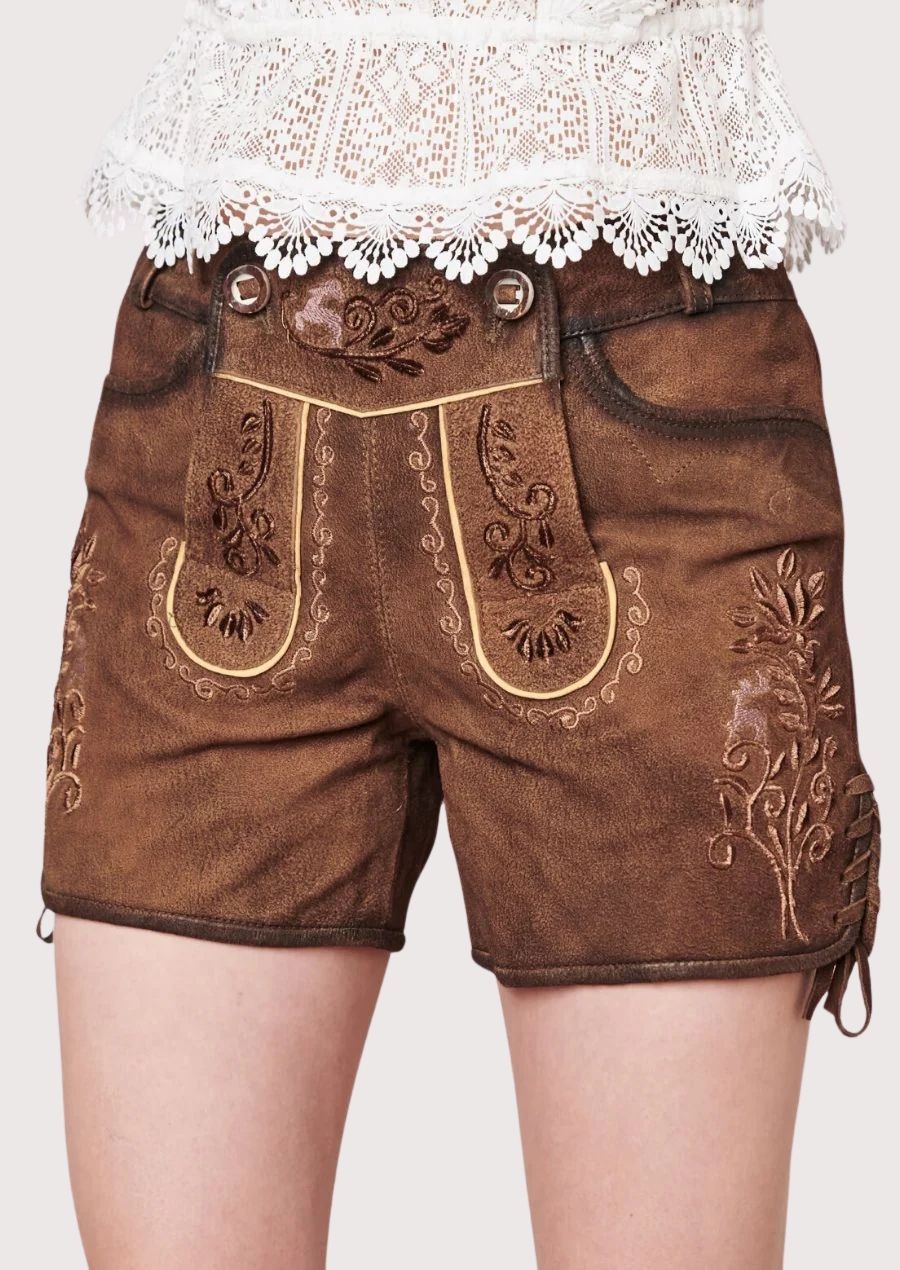 Traditional alpine women’s lederhosen shorts styled with detailed embroidery and lace blouse