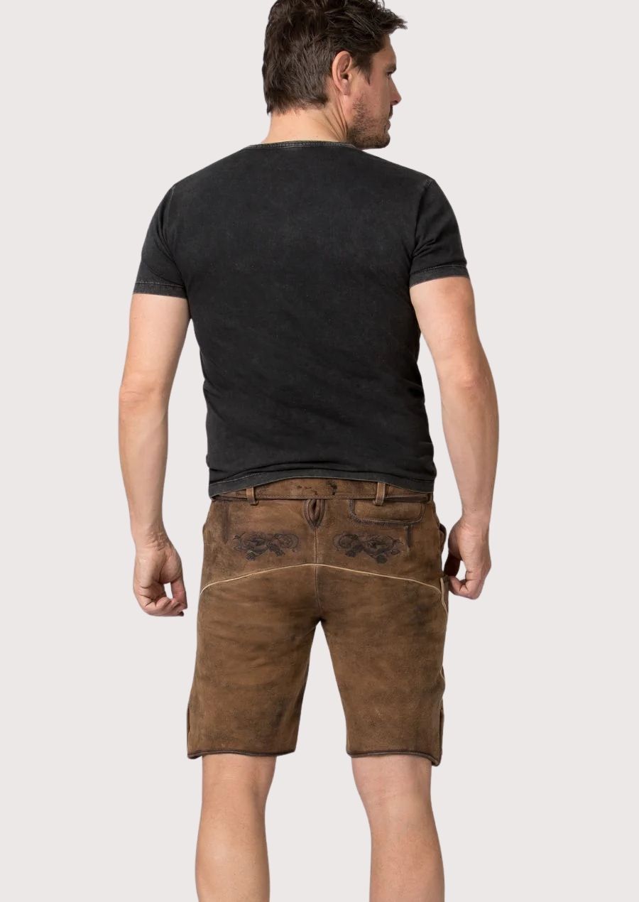 Embroidered Bavarian lederhosen shorts styled with a black biker graphic tee and rugged heritage appeal