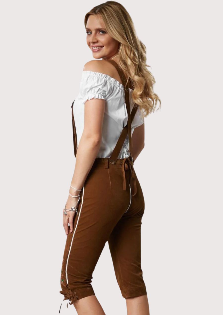 Chestnut brown women's lederhosen with floral embroidery, white piping, suspenders, and knee-length fit.
