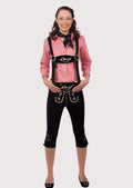 Women's black knee-length lederhosen with suspenders, silver embroidery, red gingham Trachten shirt, and Alpine scarf.