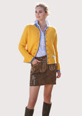 Woman wearing a premium brown suede Trachten mini skirt with embroidered leather detailing, paired with a mustard knit cardigan and blue check shirt.