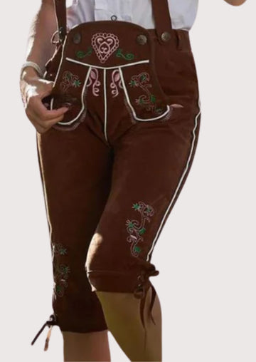 Women's chestnut brown suede lederhosen with embroidered suspenders, floral detailing, and knee-length Bavarian design.