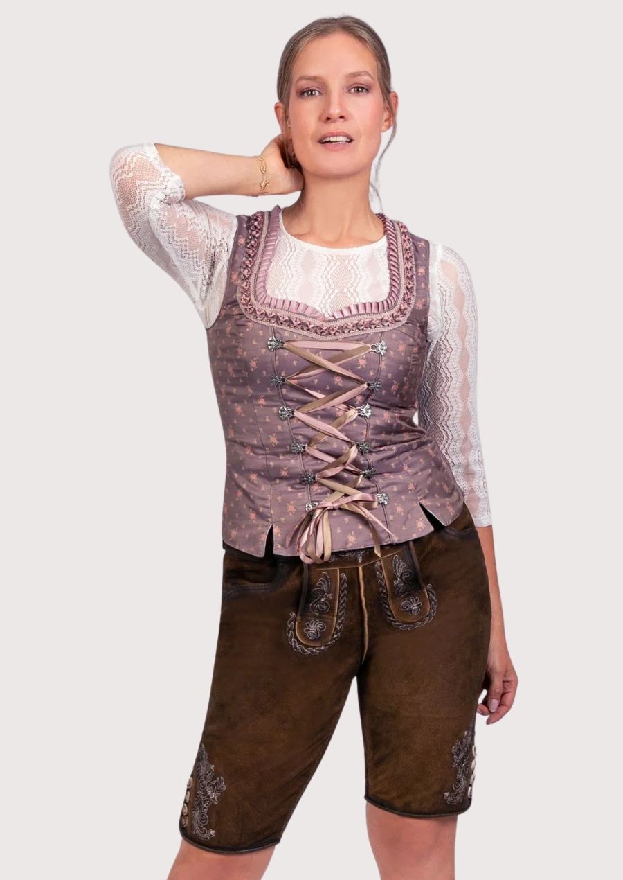Woman wearing traditional dirndl-style corset top paired with embroidered lederhosen shorts