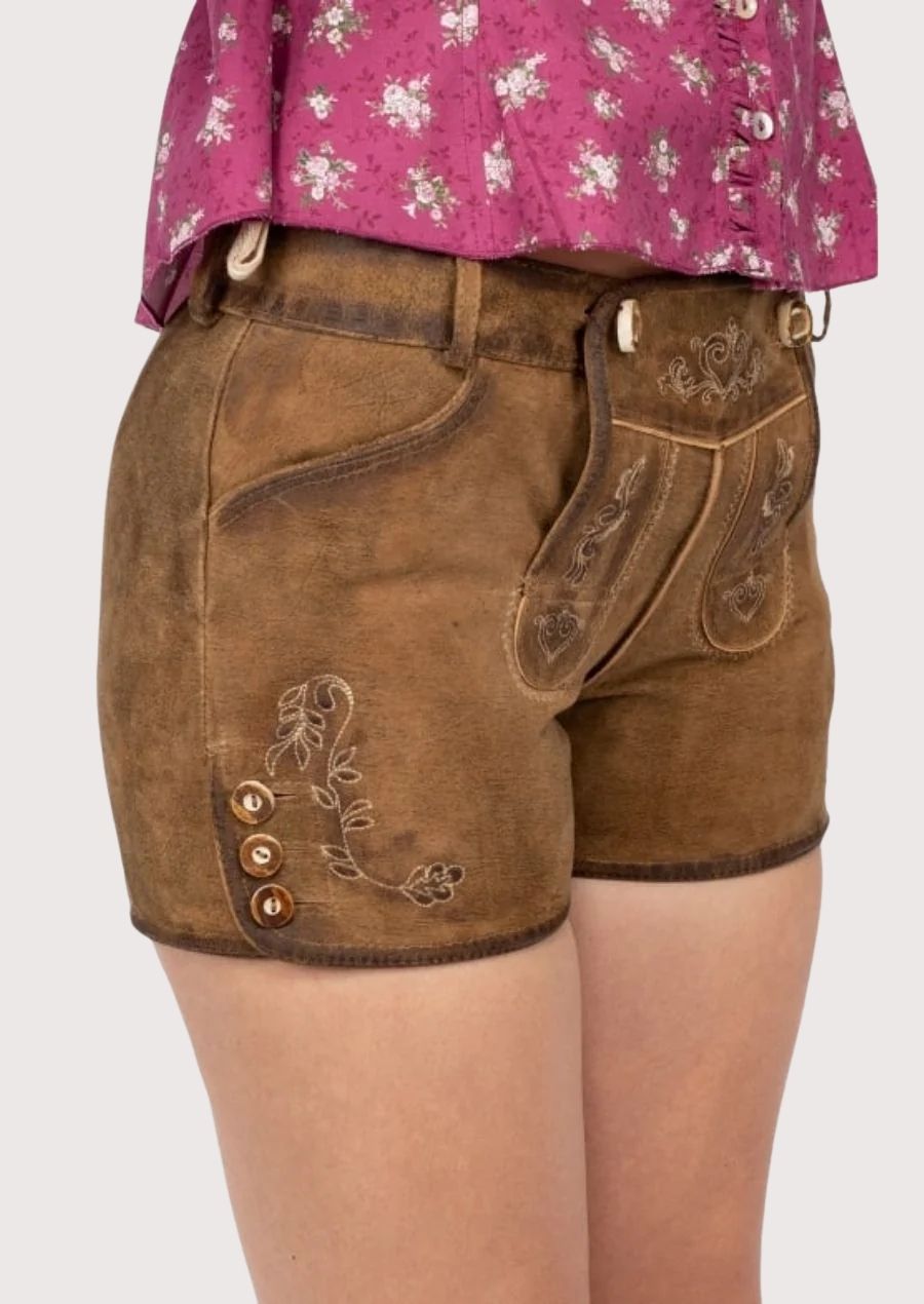 Timeless women’s lederhosen made from soft suede leather with adjustable fit and floral detailing, ideal for Oktoberfest, cultural gatherings, and casual outings.