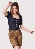 Woman wearing brown embroidered lederhosen styled with navy blue Bavarian blouse