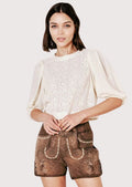 Vintage-style women’s brown lederhosen shorts with traditional embroidery and cream blouse