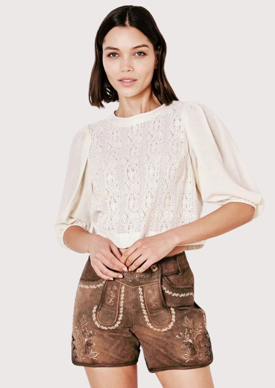 Vintage-style women’s brown lederhosen shorts with traditional embroidery and cream blouse